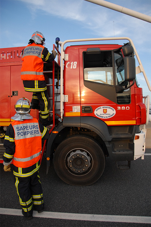 Les pompiers montant sur leur camion